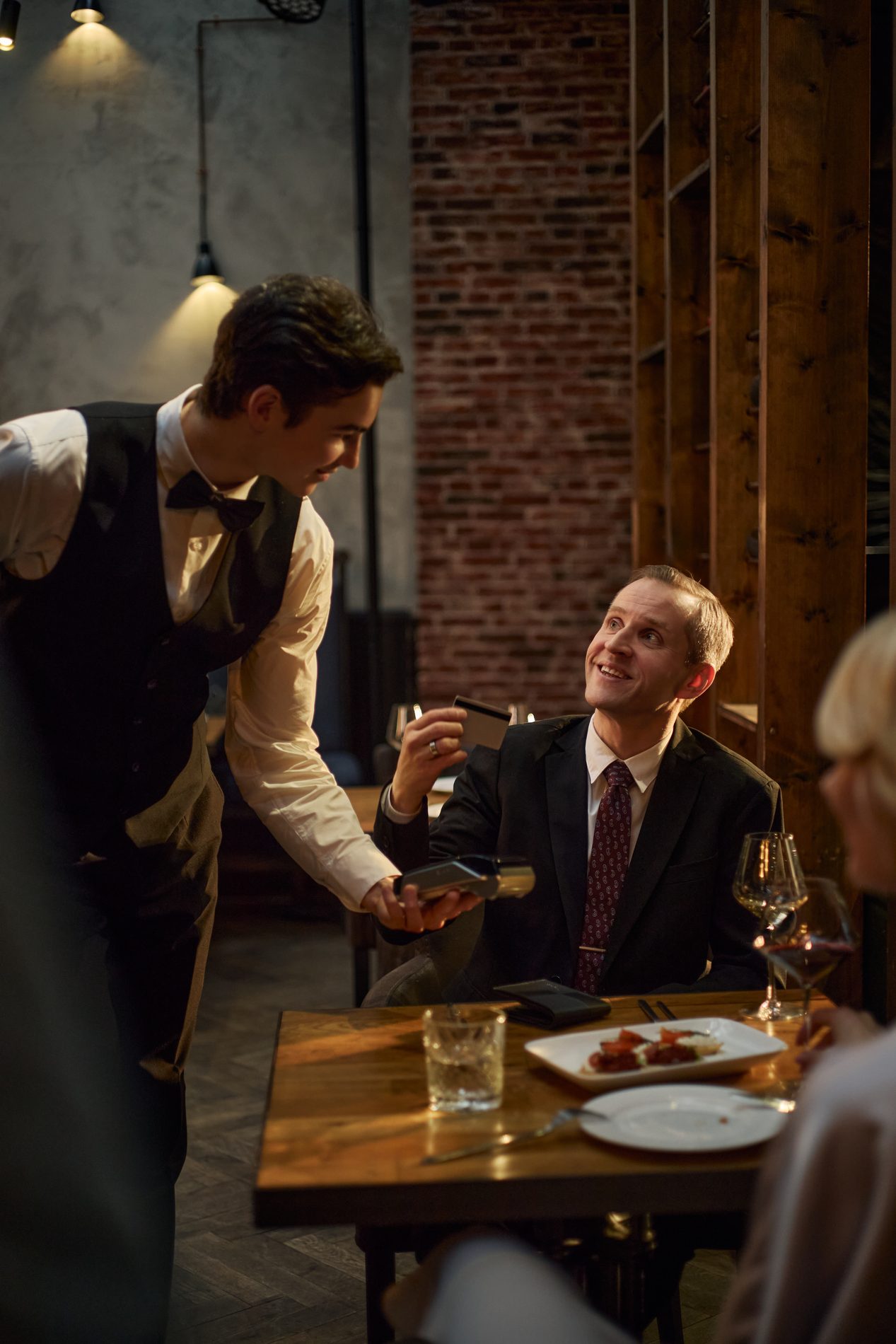 Server taking a tableside card payment at a restaurant